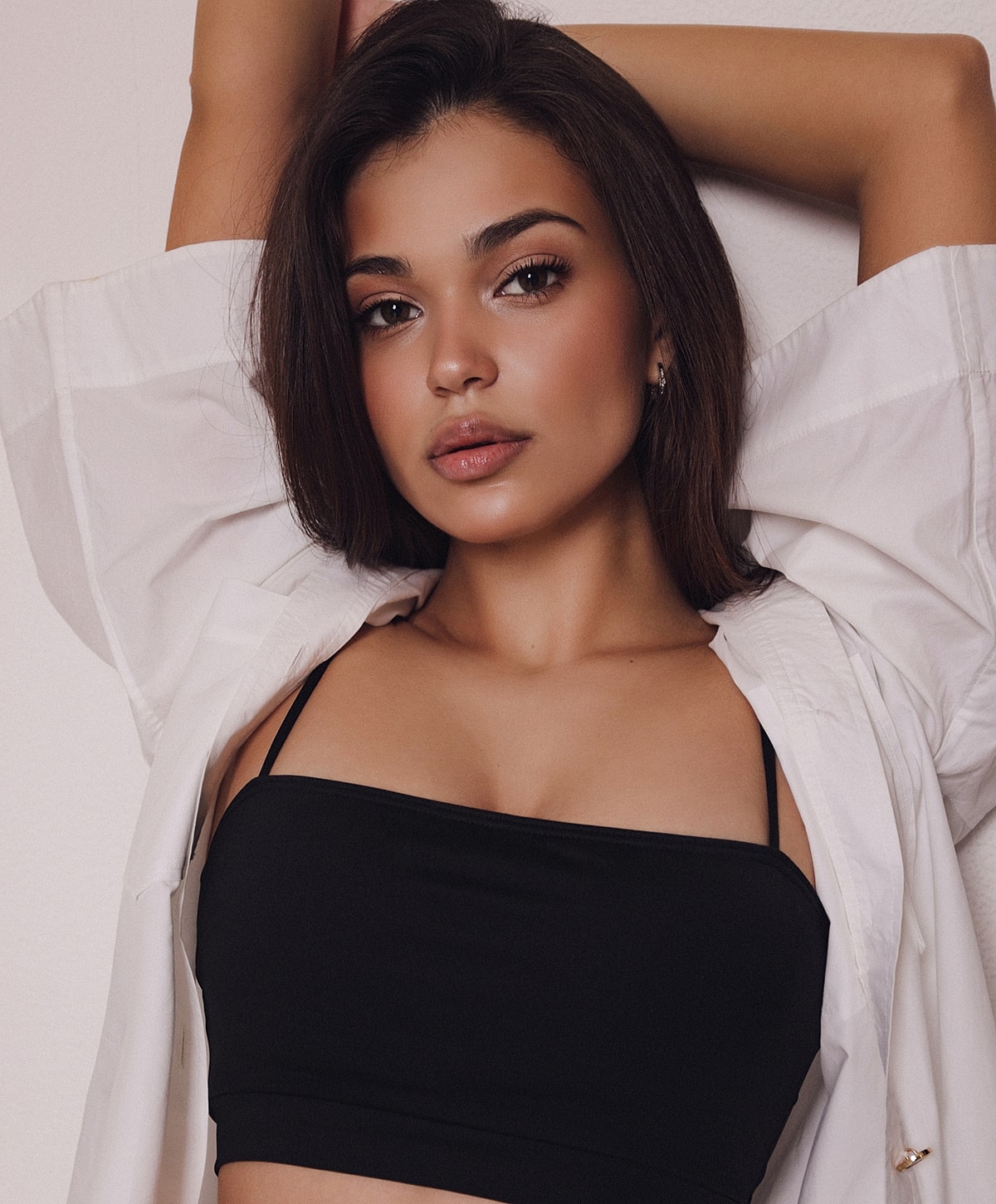Woman in casual pose, wearing black top.