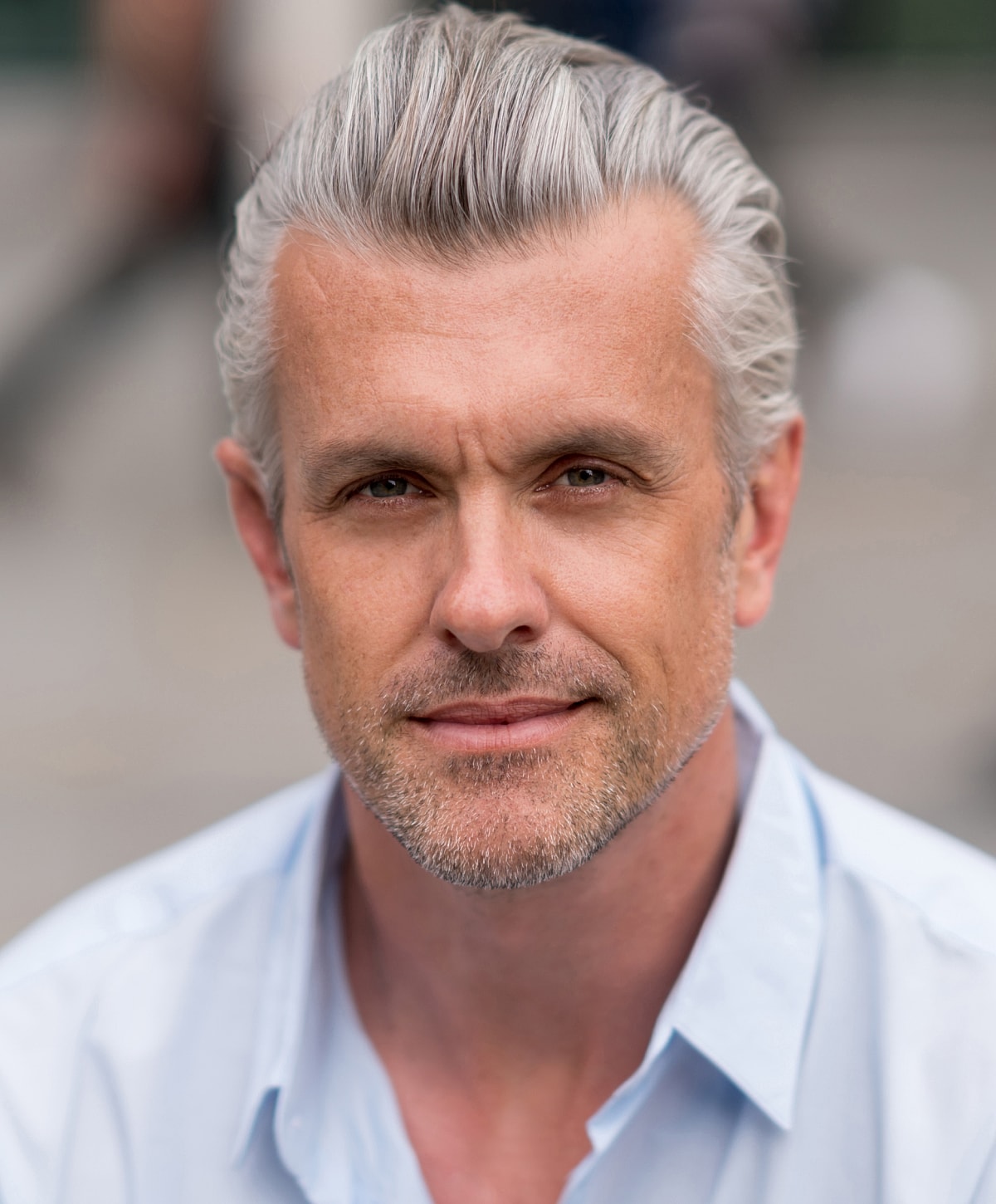 Smiling man with gray hair and beard.