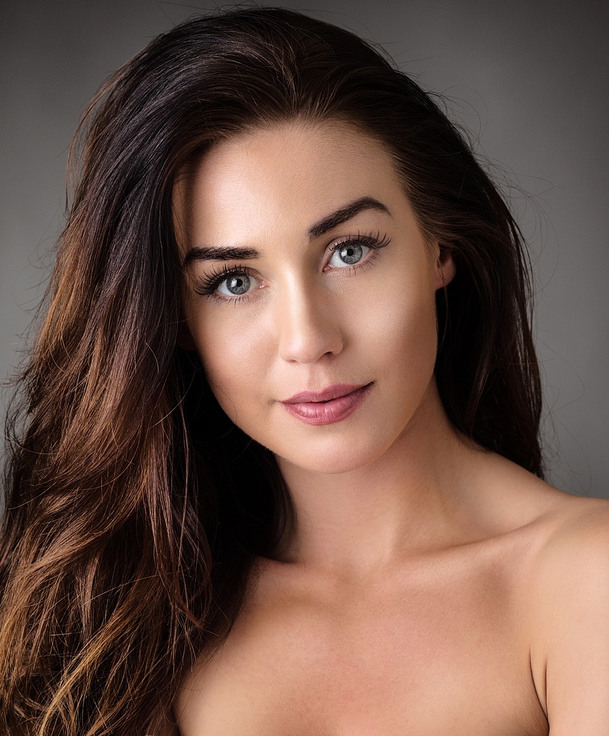 Woman with long hair and striking blue eyes.