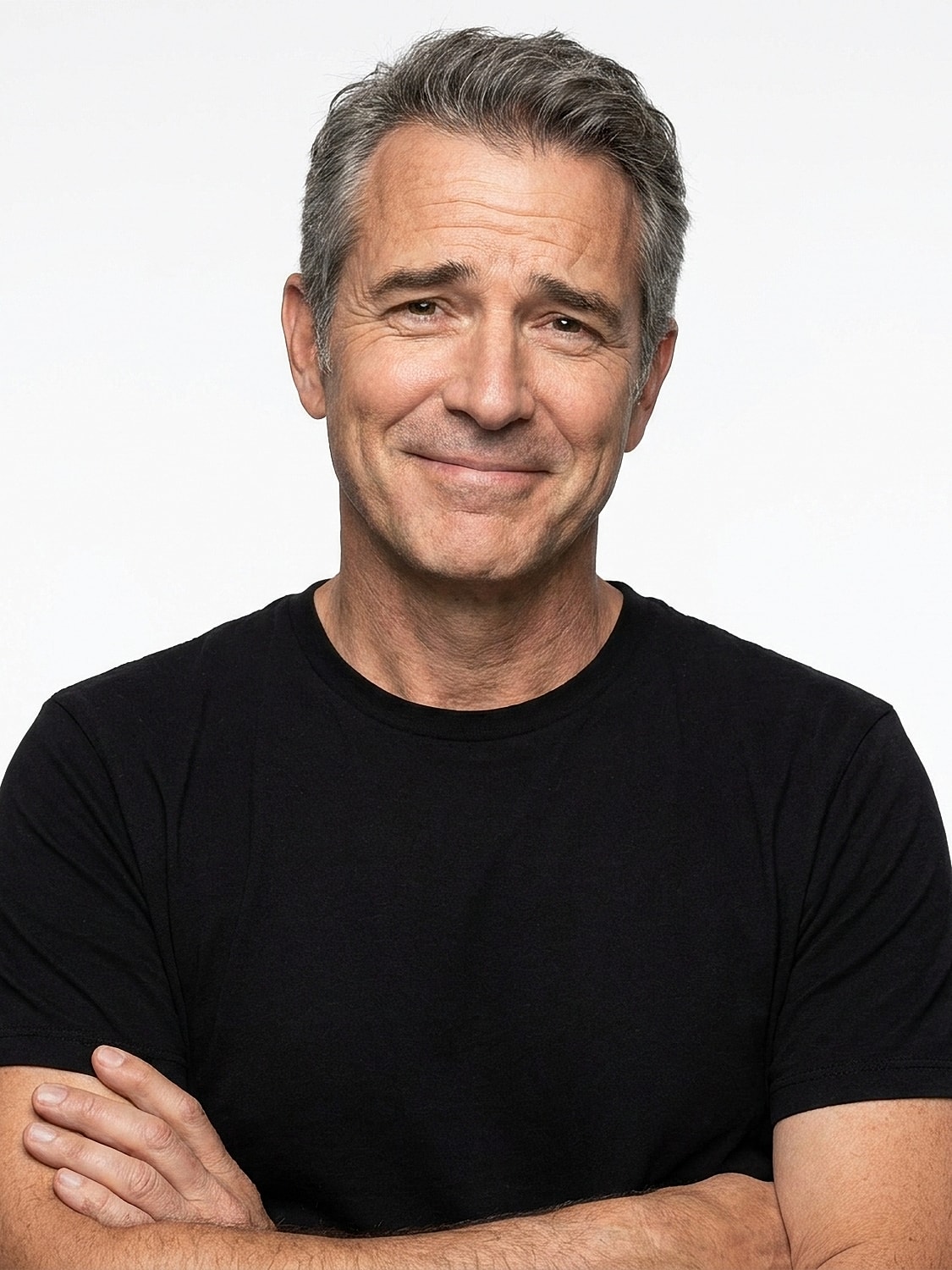 Smiling man in a black t-shirt, arms crossed.