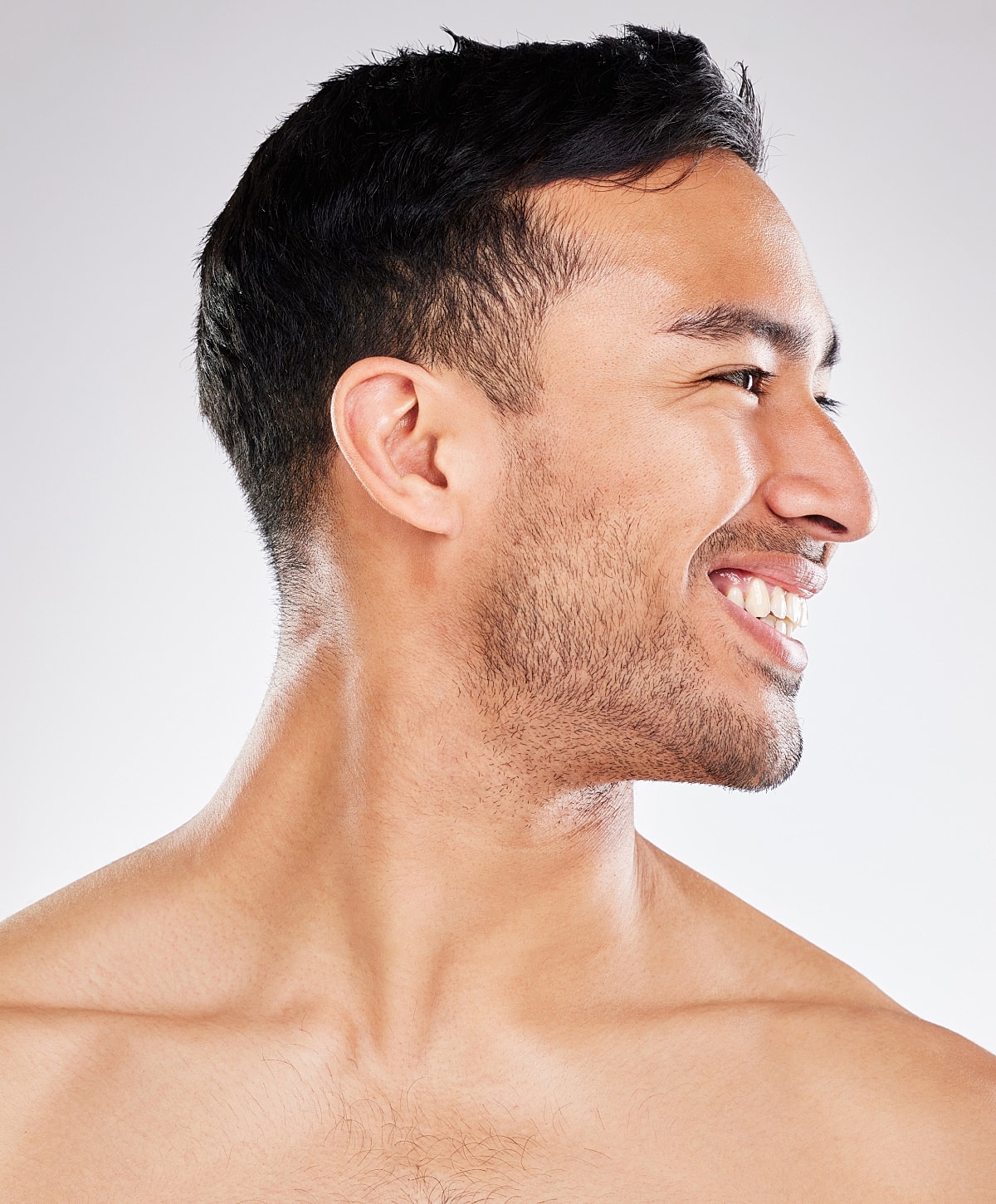 Smiling man's profile against a plain background.