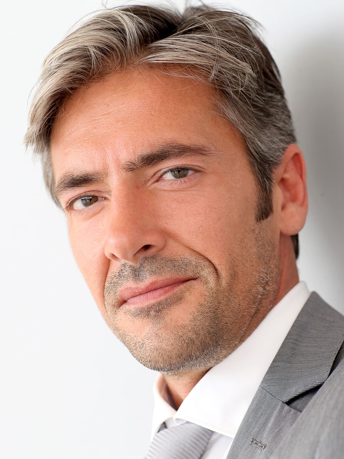 Smiling man in a gray suit portrait.