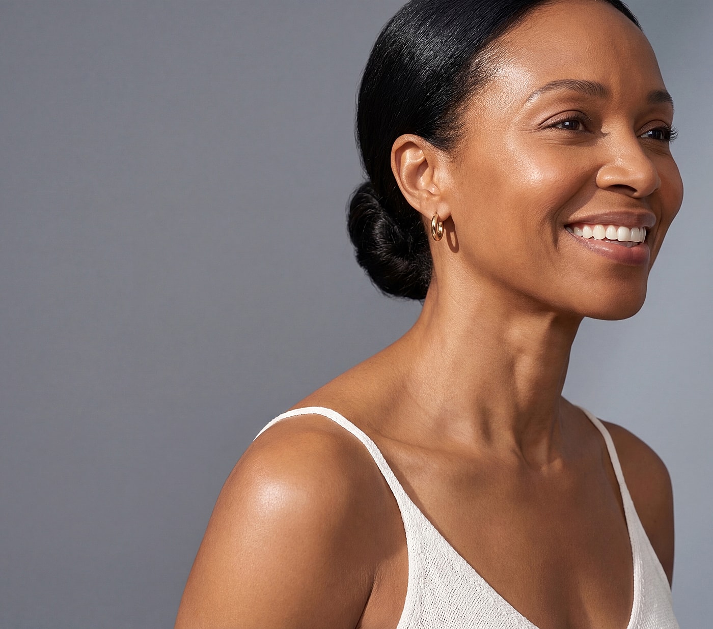Smiling woman with bun hairstyle and earrings