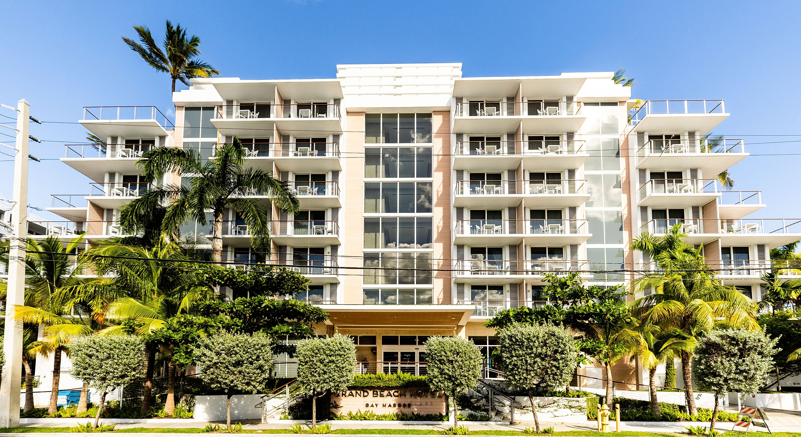 Modern hotel building surrounded by palm trees.