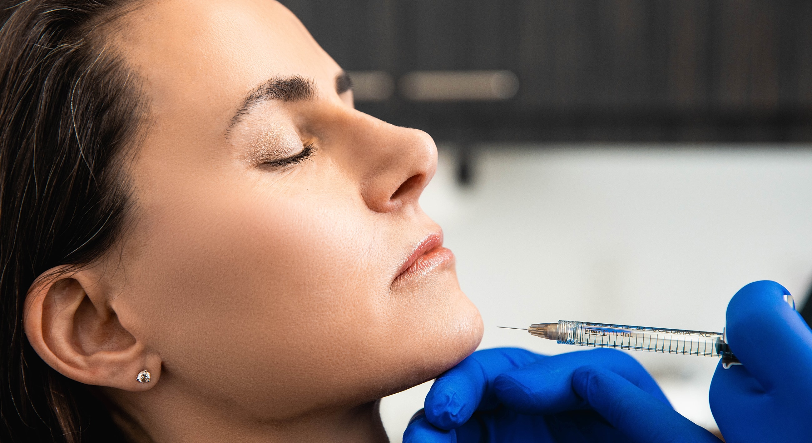 Administering cosmetic treatment to a woman's face.