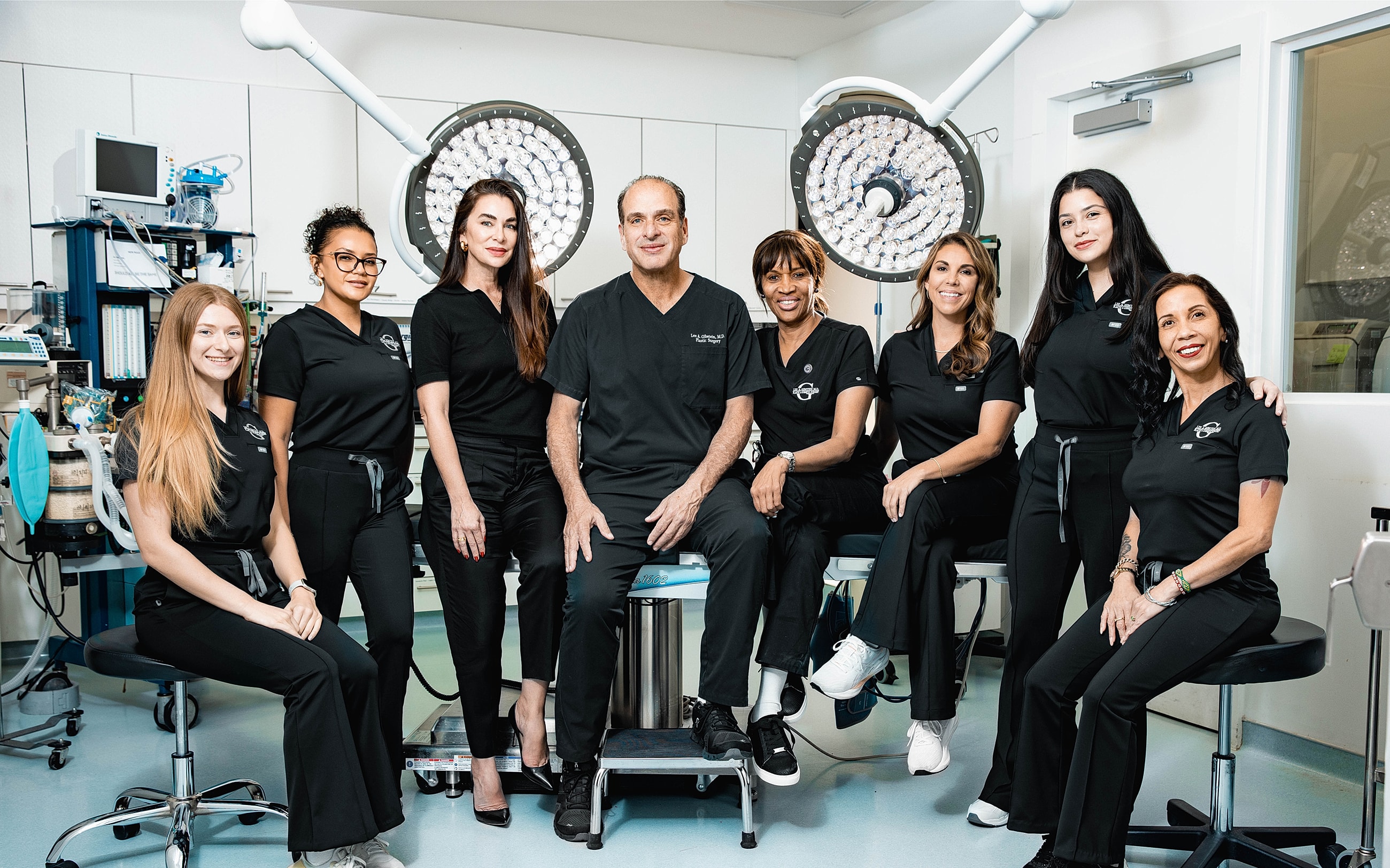 Medical team in surgical attire, smiling together.