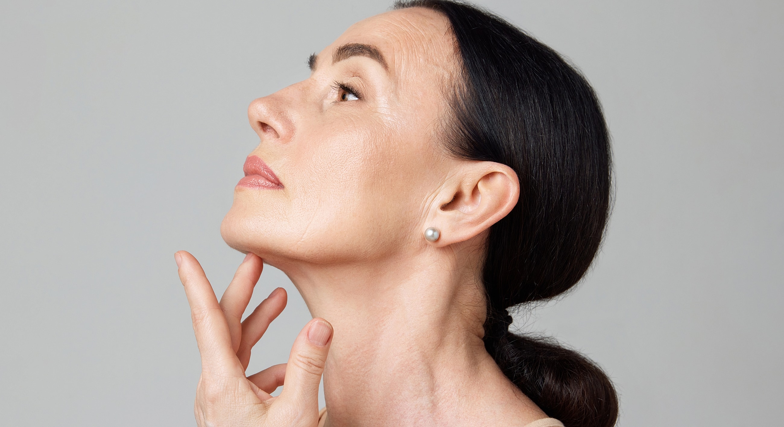 Profile view of woman touching her chin.